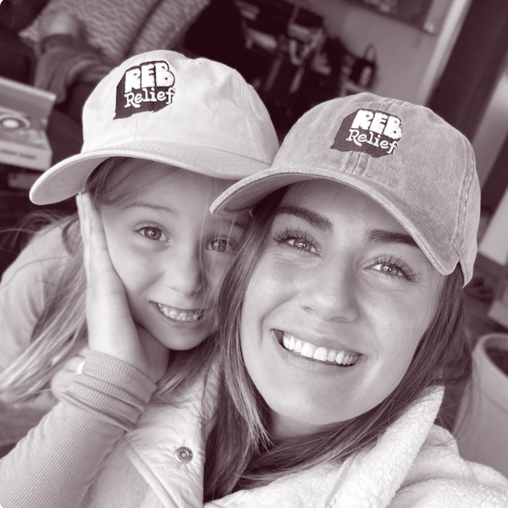 Kate and Riley smiling together in REB caps