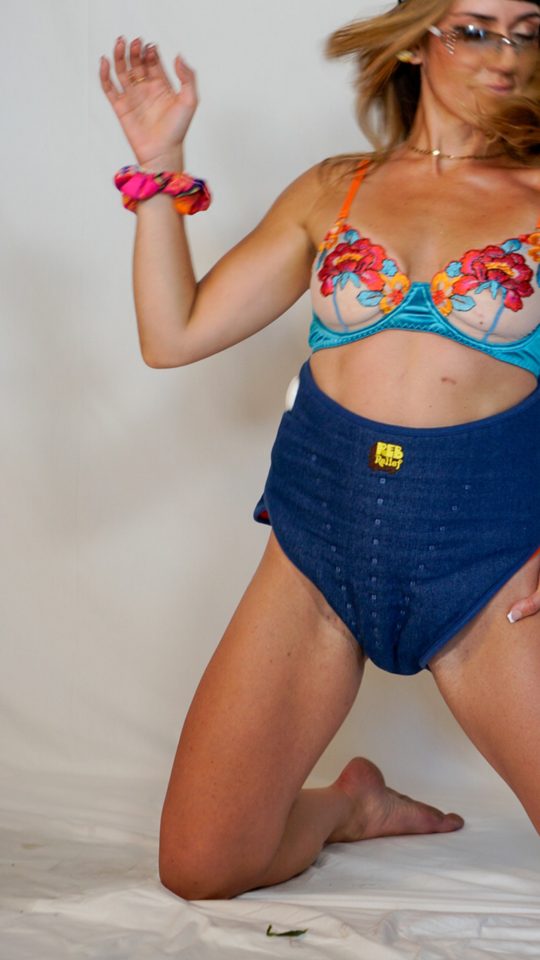Woman kneeling in a navy REB heating pad
