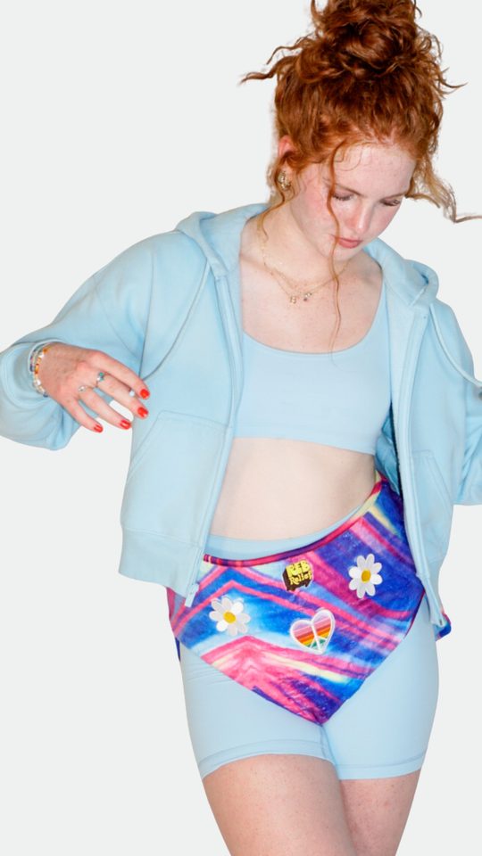 Woman in blue showing a colorful REB heating pad