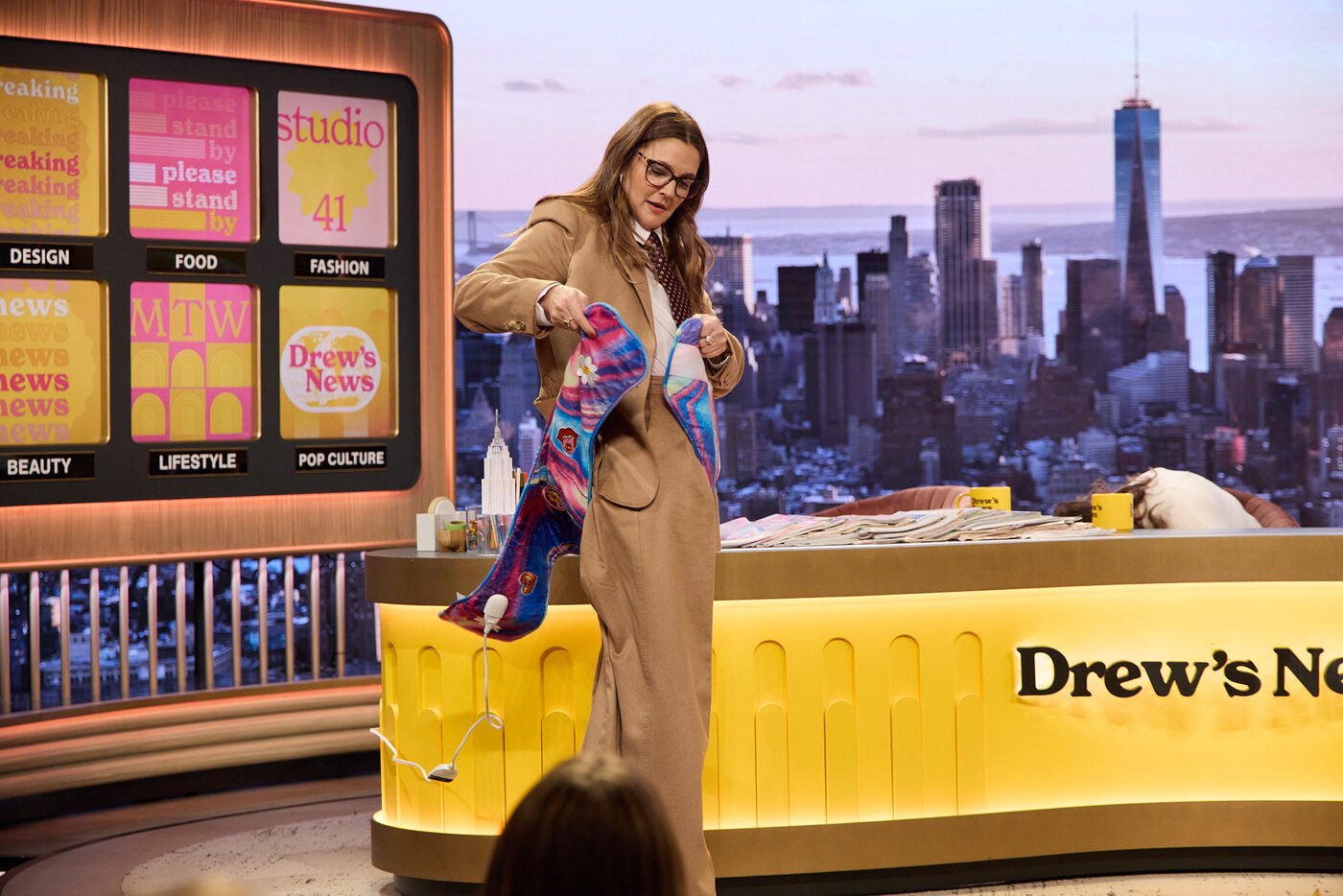 Drew Barrymore holding a REB heating pad in her studio